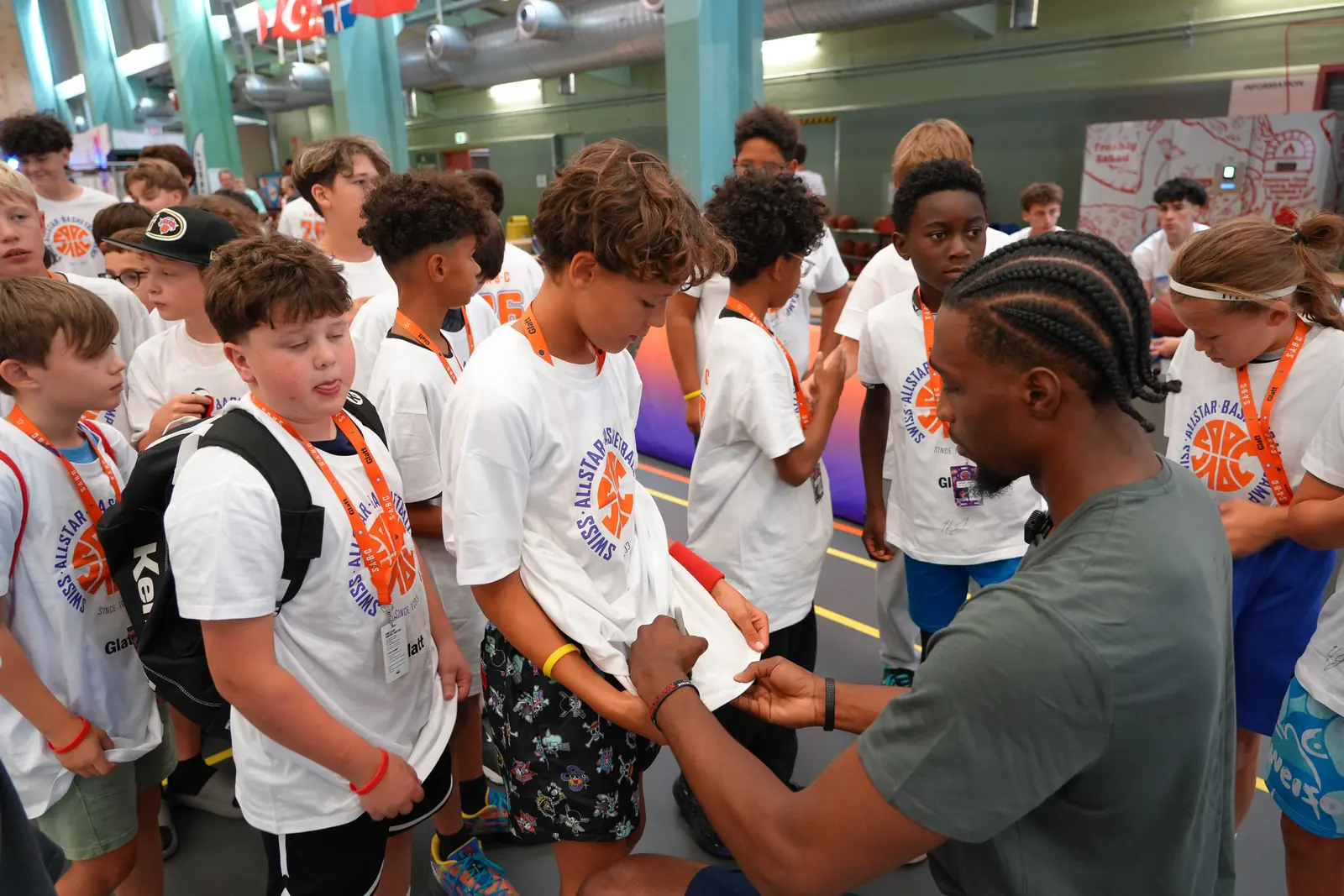 Ein Trainer schreibt Autogramme für Kinder in Camp-Shirts